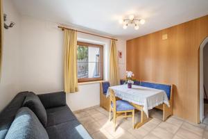 a living room with a table and a couch at Gartnerhof Apt Rose in Colle Isarco +10 photos