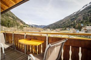 a table and chairs on a balcony with mountains at Gartnerhof Apt Rose in Colle Isarco