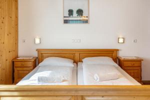 a bedroom with two beds and two night stands at Gartnerhof Apt Rose in Colle Isarco