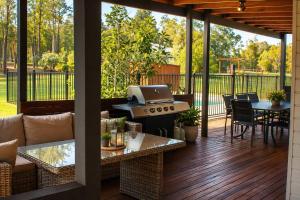 a screened in porch with a grill and a table at Stay at Shiraz in Pokolbin