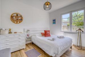 a bedroom with a bed and a dresser and a window at Maison Côté Bassin in Arcachon +25 photos