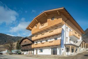 a building with a wooden roof on top of it at Balbeinhof Apt Reh in Luson