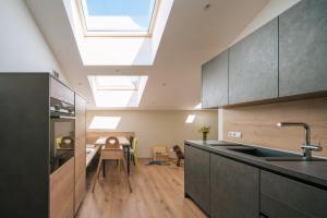 an attic kitchen with a skylight and a dining table at Balbeinhof Apt Reh in Luson