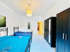 a bedroom with a blue bed and a hallway at - The White Marble Beach Housefree in Marina di Carrara