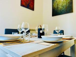 a table with white plates and wine glasses on it at - The White Marble Beach Housefree in Marina di Carrara +14 photos