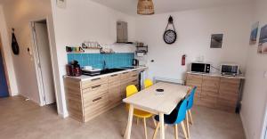 a kitchen with a table and chairs in a room at Le studio d'Apoline avec piscine in La Tranche-sur-Mer