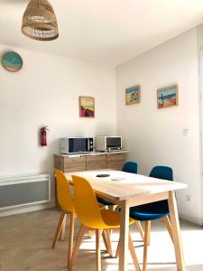 a dining room with a table and chairs at Le studio d'Apoline avec piscine in La Tranche-sur-Mer