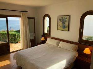 a bedroom with a bed and a view of the ocean at Villa Solymar in Cala Serena +28 photos