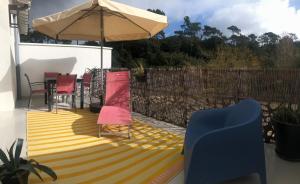 a patio with a table and chairs and an umbrella at Le studio d'Apoline avec piscine in La Tranche-sur-Mer