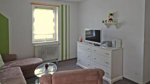 a living room with a couch and a tv at Sommergarten mit Winternutzung in Karlshagen