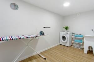 a white laundry room with a washer and dryer at O Marinheiro 15B in Machico