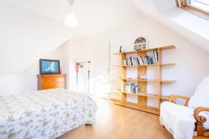 a bedroom with a bed and a book shelf at Ty Bénodet - Maison de vacances in Bénodet