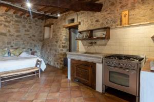 a kitchen with a stove and a bed in a room at Camera con Vista in Anghiari