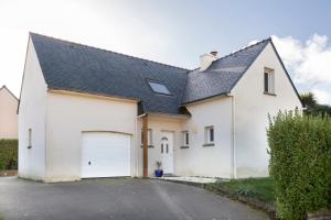 a white house with a garage at Ty Bénodet - Maison de vacances in Bénodet