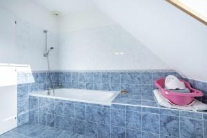 a bathroom with a bath tub and a pink baby stroller at Ty Bénodet - Maison de vacances in Bénodet +17 photos