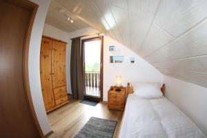 a small bedroom with a bed and a window at Ferienhaus Da Vinci in Kirchheim