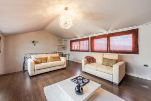 a living room with two couches and a table at Tranquility Villa with Pool Private Garden & BBQ by PikHost in Tirana +57 photos