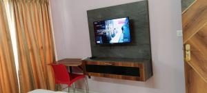 a room with a tv and a desk with a red chair at Elixir Boarding & Lodging in Bangalore