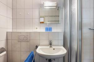 a white bathroom with a sink and a mirror at Wohnung Claudia mit Balkon in Todtnau +18 photos