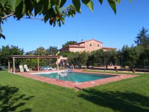 a swimming pool in a yard with a house in the background at Mas Pareta - La Parra in Fonolleras