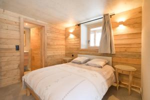 a bedroom with a white bed and a window at Lisalice appartement in Les Villards-sur-Thônes