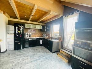 a kitchen with a black refrigerator and a tv at Ferienwohnung Allgäunest in Argenbühl