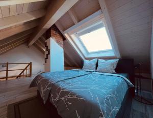 a bedroom with a blue bed in a attic at Ferienwohnung Allgäunest in Argenbühl
