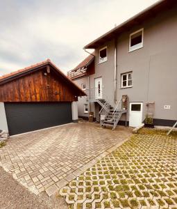 a house with a garage and a staircase in front of it at Ferienwohnung Allgäunest in Argenbühl