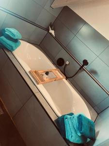 a bathroom with a tub with blue towels in it at Ferienwohnung Allgäunest in Argenbühl +22 photos