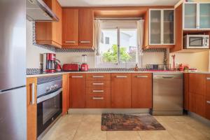 a kitchen with wooden cabinets and a window at Mediterranean Vacation in Mallorca in Cala Pi