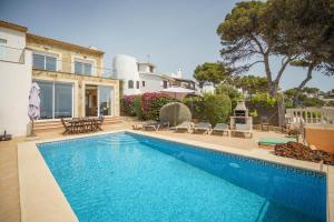 a swimming pool in front of a house at Mediterranean Vacation in Mallorca in Cala Pi