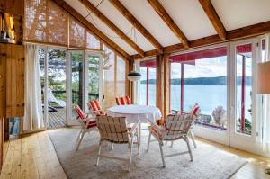 a dining room with a table and chairs with a view of the water at Adlerhorst über dem Bodensee in Sipplingen