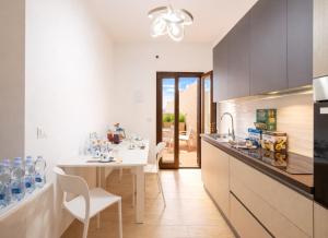 a kitchen with a white table and chairs and a dining room at Quintessenza – Boutique Rooms in Leverano