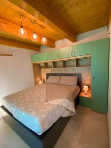 a bedroom with a bed with green cabinets and lights at Alpi Liguri - Villa Giulia in Peveragno