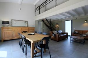 a dining room and living room with a table and chairs at Gîte Basmatho in Yvrac