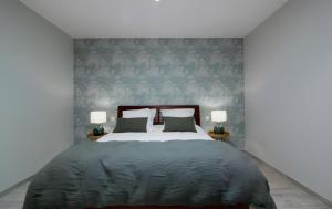 a bedroom with a large bed with two lamps at Gîte Basmatho in Yvrac