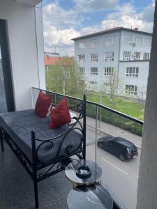a balcony with a bed with red pillows on it at Inviti Apartments in Gjakove
