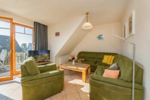 a living room with a couch and two chairs at Ferienwohnung Fisch in Loddin