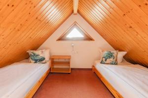 a attic bedroom with two beds and a window at Ferienwohnung Fisch in Loddin