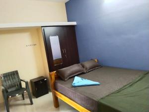 a small bedroom with a bed and a chair at CloudGuestHouse in Kottakupam