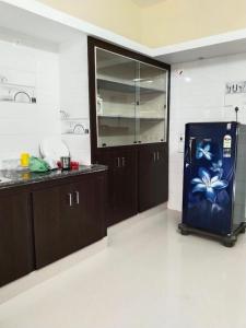 a kitchen with a refrigerator in the middle of a room at CloudGuestHouse in Kottakupam