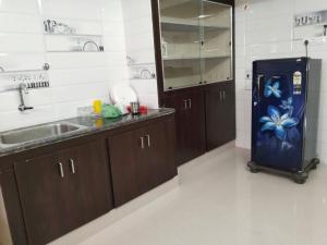 a kitchen with a sink and a refrigerator in it at CloudGuestHouse in Kottakupam