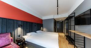 a bedroom with a bed and a tv and a chair at Tallink Express Hotel in Tallinn