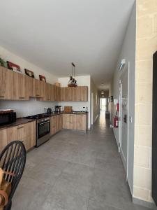 a large kitchen with wooden cabinets and a large tile floor at Azure Dome Residences in Għajnsielem
