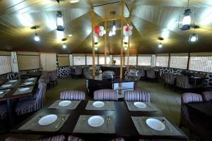 a dining room with tables and chairs in a restaurant at Agyaat Vaas in Bāgi