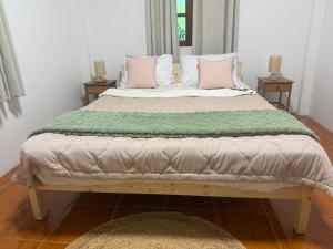 a bedroom with two beds with pink and white pillows at Siam phangan in Ko Phangan