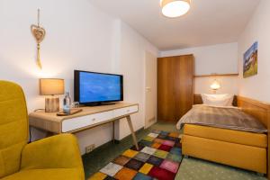 a small room with a television and a bed at Hotel Liberia in Oberstdorf