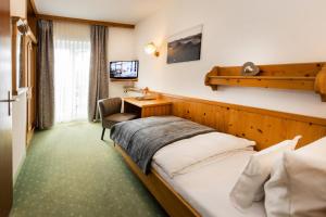 a hotel room with a bed and a desk at Hotel Liberia in Oberstdorf