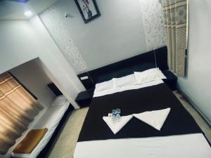 a bedroom with a black and white bed with white pillows at Bbhakt niwas in Tuljapur