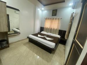 a small bedroom with a bed and a mirror at Bbhakt niwas in Tuljapur +3 photos